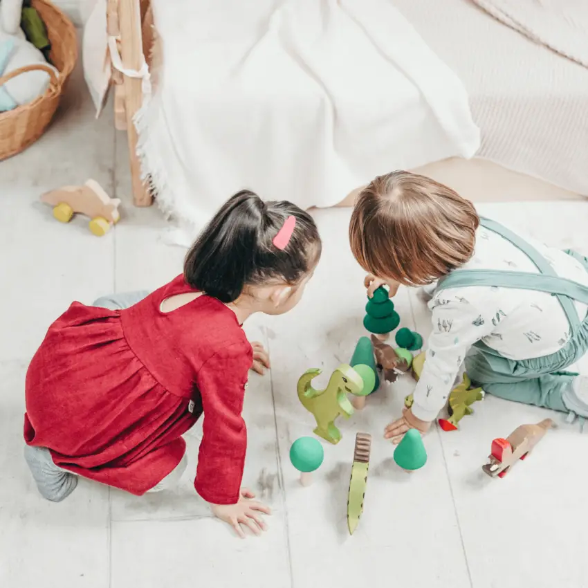 2 toddlers playing on the floor.